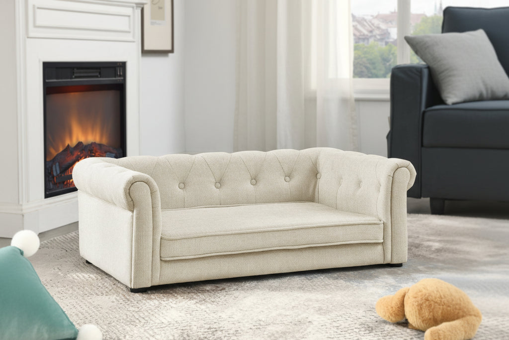 Beige tufted sofa in a living room with a fireplace and window.